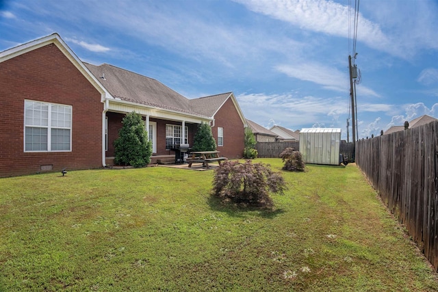  - fenced backyard with a shed and a patio area