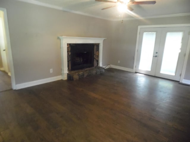  - unfurnished living room with french doors, ornamental molding, dark wood finished floors, a ceiling fan, and a fireplace