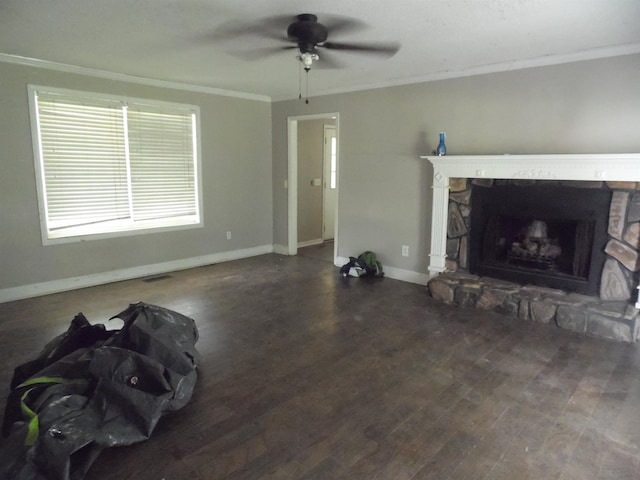  - unfurnished living room with ornamental molding, a ceiling fan, wood finished floors, and a stone fireplace