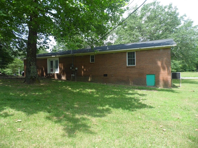  - rear view of property featuring a yard, brick siding, and crawl space