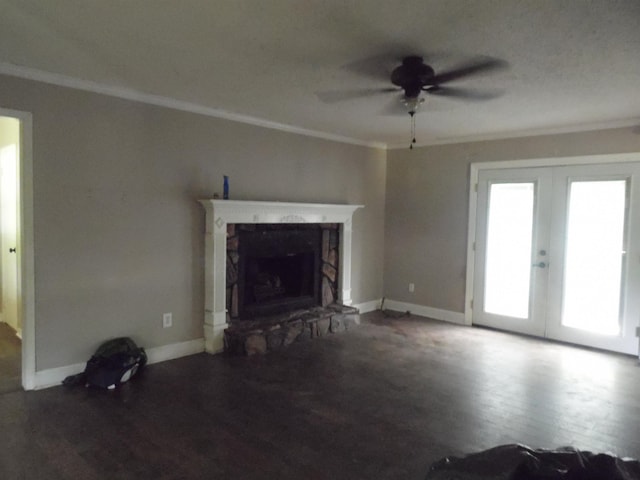  - unfurnished living room with ceiling fan, wood finished floors, ornamental molding, french doors, and a stone fireplace