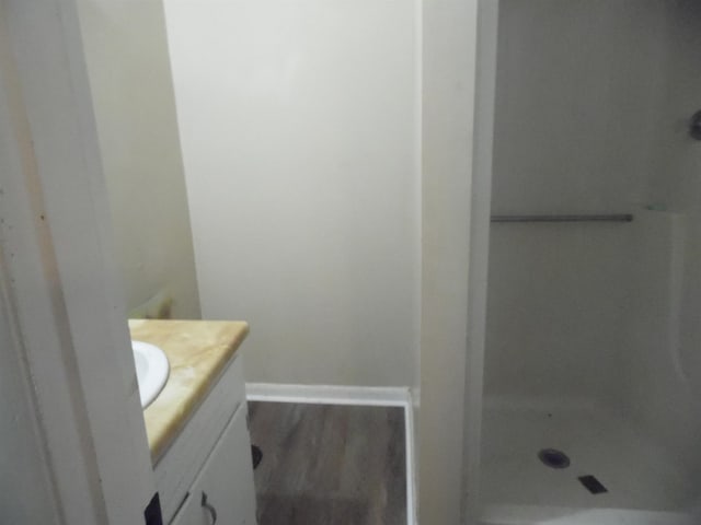  - full bathroom with vanity, a stall shower, and wood finished floors