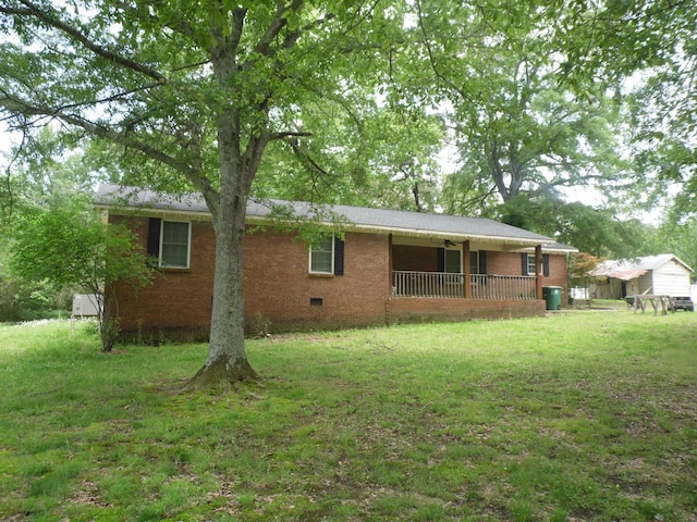 - back of property featuring a ceiling fan, crawl space, a lawn, and brick siding