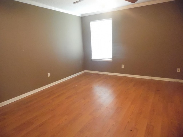  - empty room with crown molding, light wood-style flooring, and a ceiling fan