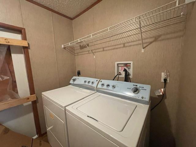 washroom with a textured ceiling and washer and clothes dryer