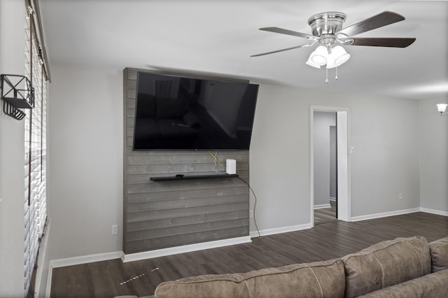 living area featuring baseboards, wood finished floors, and ceiling fan