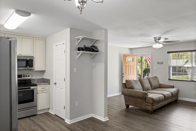 kitchen with stainless steel appliances, open floor plan, baseboards, ceiling fan, and dark wood-type flooring