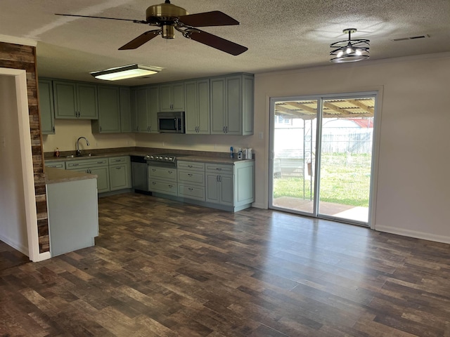 kitchen featuring stainless steel microwave, cooktop, dark wood-type flooring, and visible vents