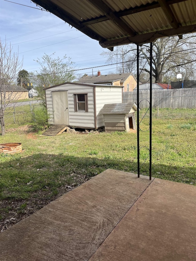 view of yard featuring a patio area, fence, and an outdoor structure