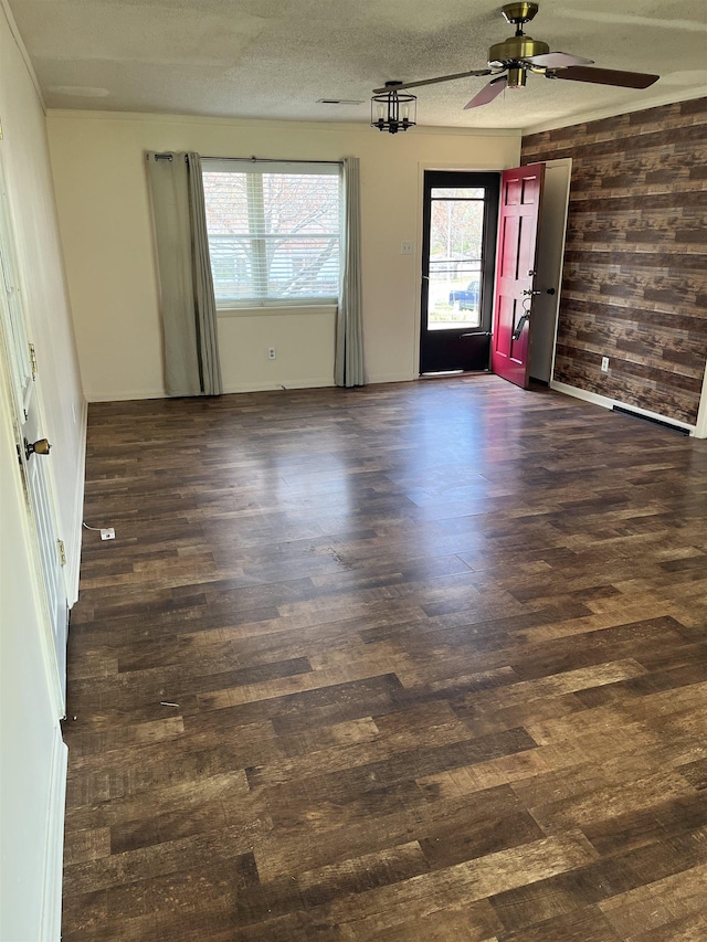 empty room with a textured ceiling, ceiling fan, and wood finished floors