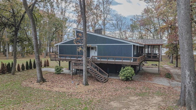 - back of property featuring stairs, metal roof, a chimney, and a wooden deck