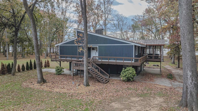 back of property featuring stairs, metal roof, a chimney, and a wooden deck