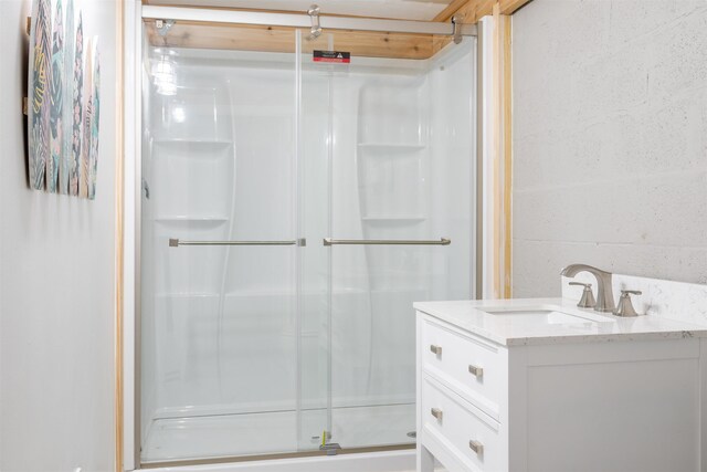 bathroom with a shower stall and vanity