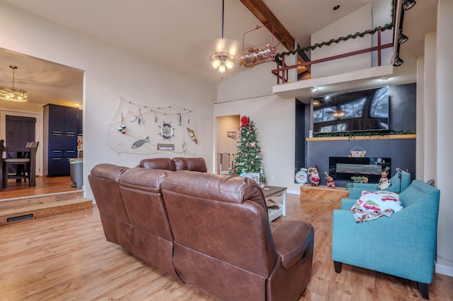 living area with high vaulted ceiling, visible vents, wood finished floors, and beamed ceiling