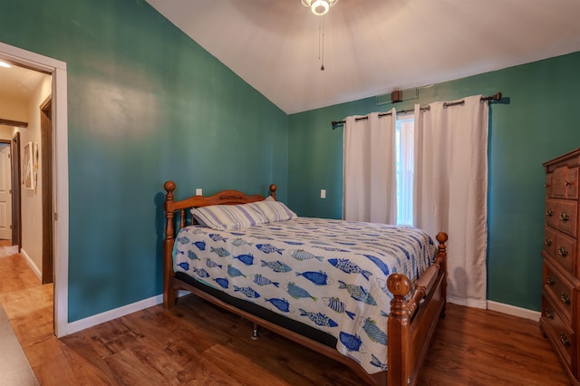 bedroom featuring baseboards, vaulted ceiling, and wood finished floors