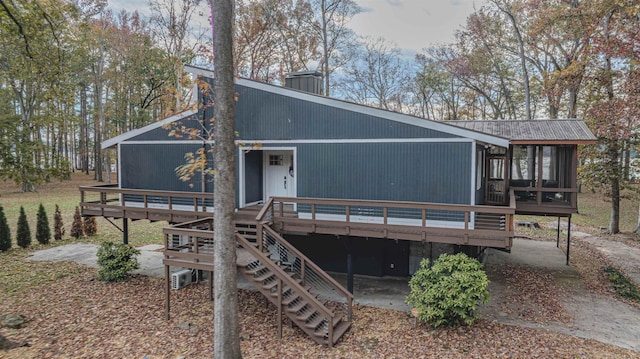 back of house featuring a chimney, a patio, and a deck