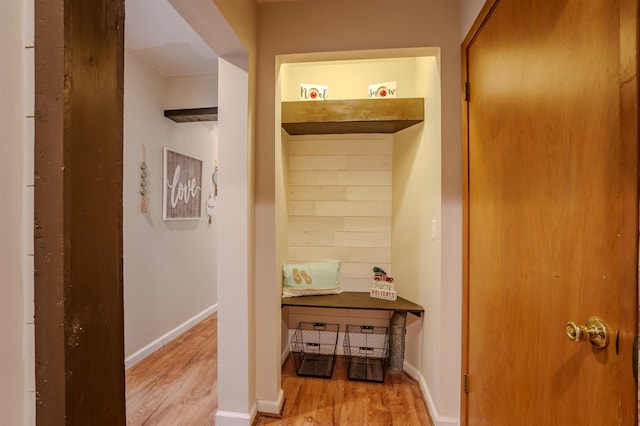 corridor featuring baseboards and wood finished floors