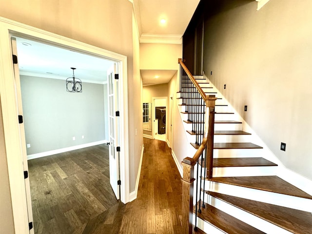 stairway featuring hardwood / wood-style flooring, an inviting chandelier, and ornamental molding