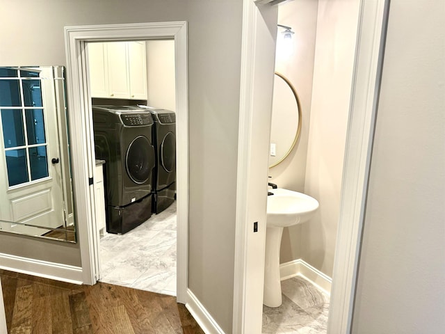 washroom featuring dark hardwood / wood-style floors, cabinets, and washing machine and clothes dryer