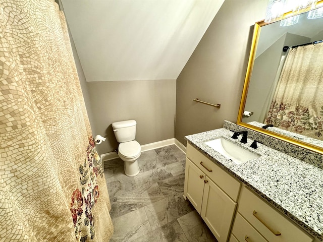 bathroom featuring vanity, toilet, and lofted ceiling