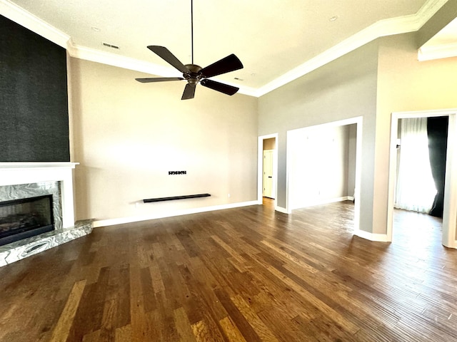 unfurnished living room featuring a high end fireplace, wood-type flooring, ceiling fan, and crown molding