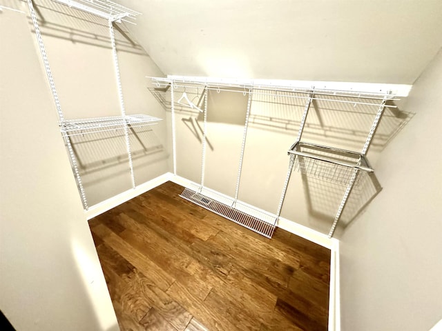 walk in closet with hardwood / wood-style flooring and lofted ceiling