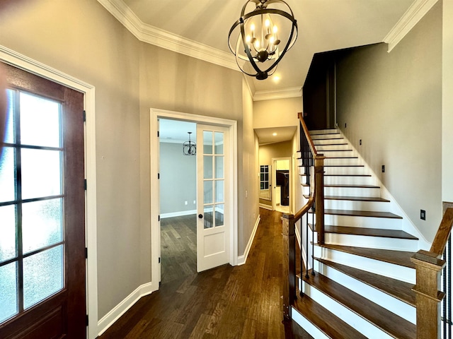 foyer entrance featuring a chandelier, french doors, dark wood-type flooring, and crown molding