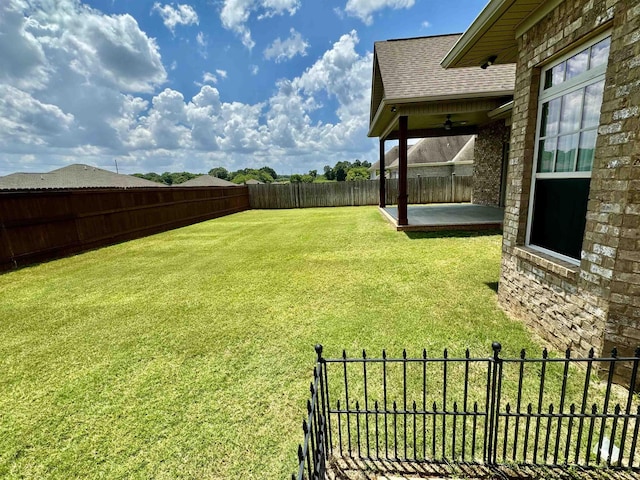 view of yard with ceiling fan and a patio