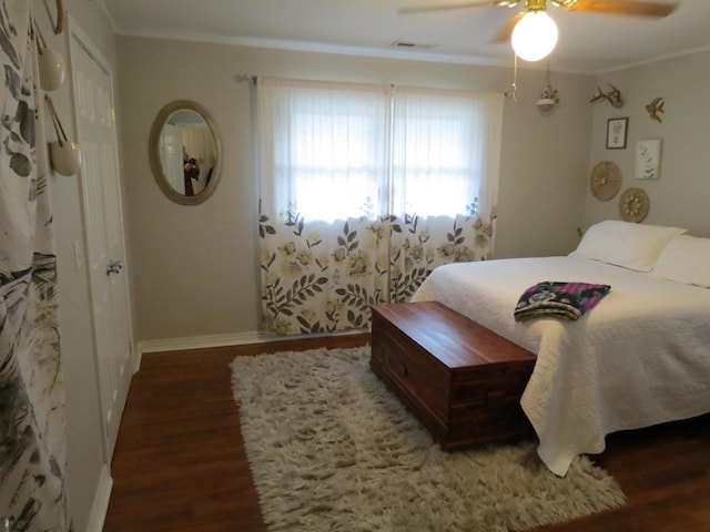 bedroom with ceiling fan, dark hardwood / wood-style floors, and ornamental molding