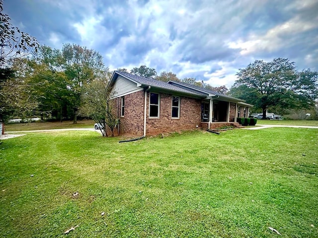 view of property exterior with a lawn and brick siding