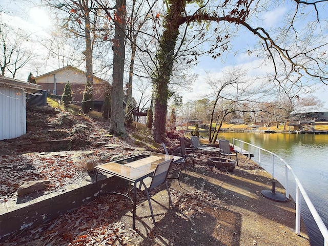 view of yard featuring a water view and a fire pit