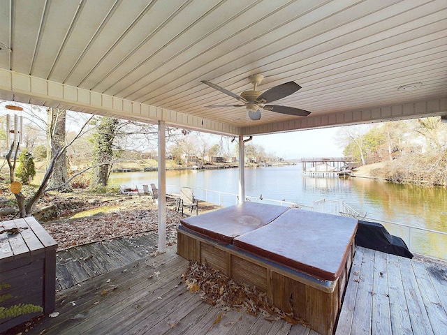 view of dock with a deck with water view and a covered hot tub