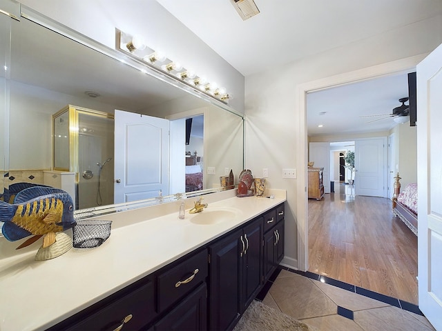 bathroom featuring tile patterned flooring, ceiling fan, an enclosed shower, and vanity