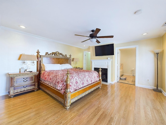 bedroom with connected bathroom, hardwood / wood-style flooring, ceiling fan, and crown molding