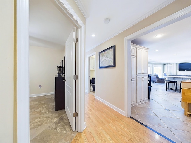 corridor with crown molding and light tile patterned floors