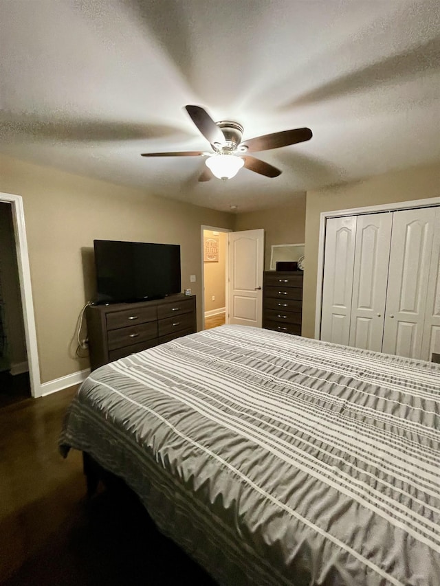 bedroom featuring dark wood-style floors, ceiling fan, baseboards, and a closet