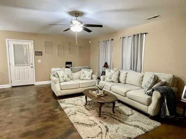 living area with a ceiling fan, visible vents, concrete floors, and baseboards