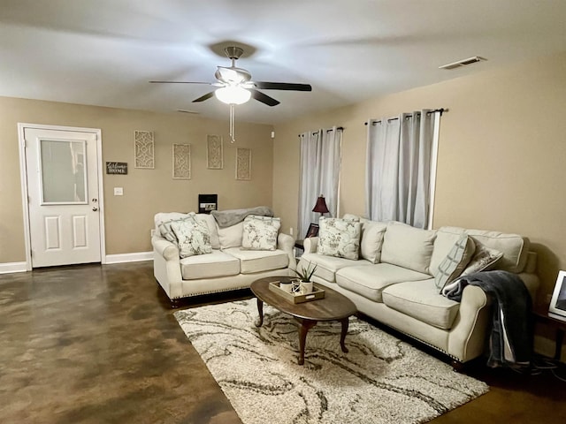 living area featuring concrete flooring, visible vents, ceiling fan, and baseboards