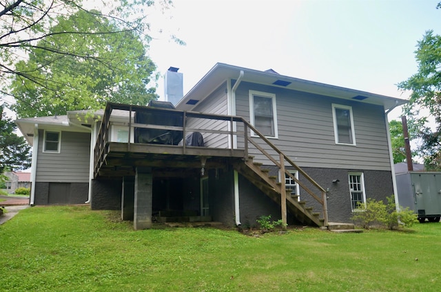  - back of property with stairway, a chimney, a lawn, and a deck