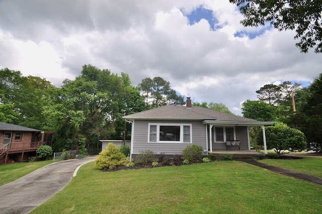  - view of front facade with covered porch, a chimney, and a front lawn