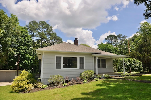  - back of house featuring a chimney, a lawn, a porch, and roof with shingles