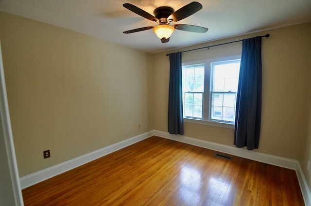  - spare room with wood finished floors, ceiling fan, and baseboards
