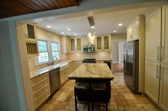  - kitchen featuring stainless steel appliances, a sink, stone tile flooring, tasteful backsplash, and recessed lighting