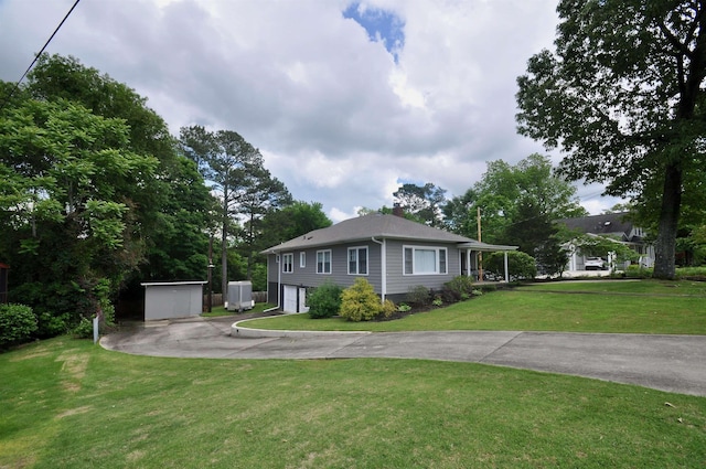  - view of front of house with driveway, a garage, a front lawn, and a chimney