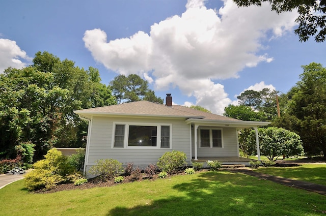  - view of front of house with a chimney, a front yard, and covered porch