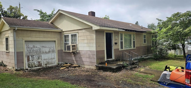  - view of side of home with a chimney, a shingled roof, cooling unit, and a garage