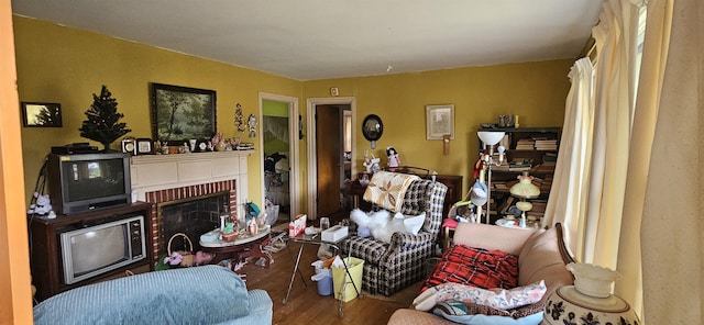  - living area with wood finished floors and a fireplace
