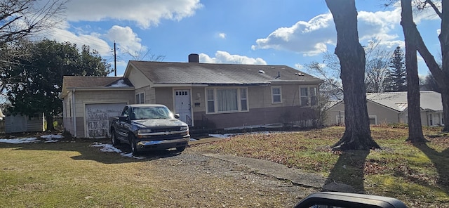  - view of front of house with a garage, a front yard, and a chimney