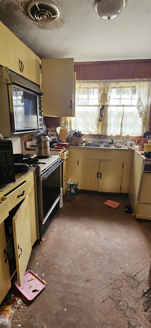  - kitchen featuring range with electric stovetop and black microwave