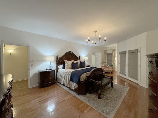 bedroom with light wood-type flooring and a notable chandelier